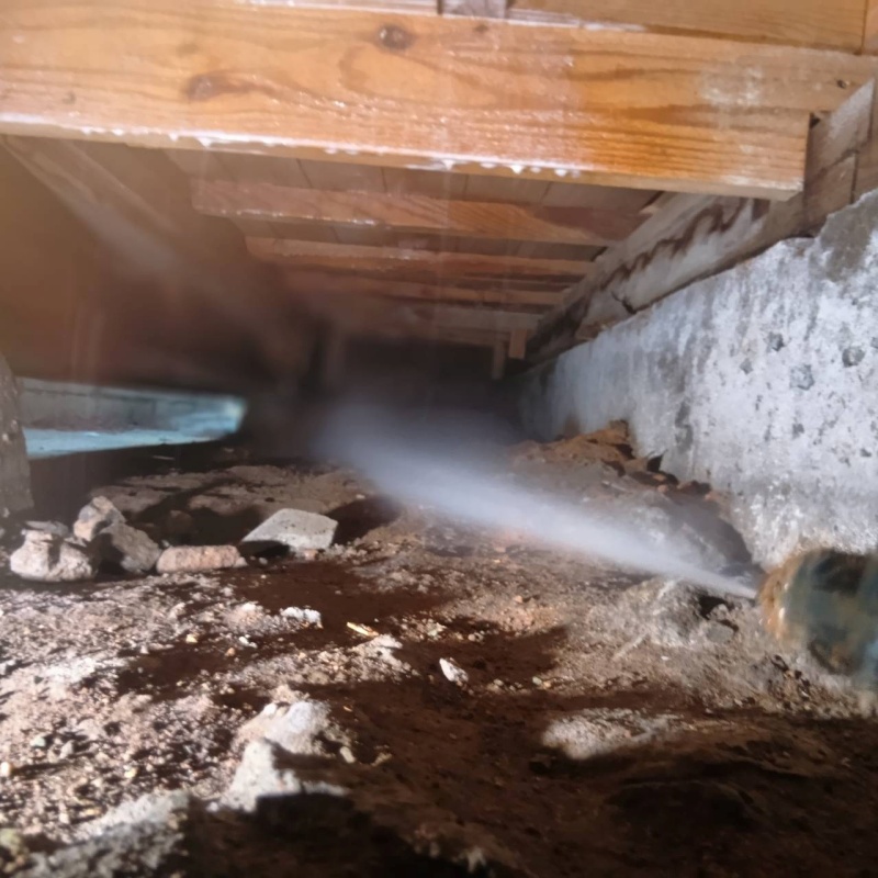 床下の土壌に防蟻剤を散布する様子