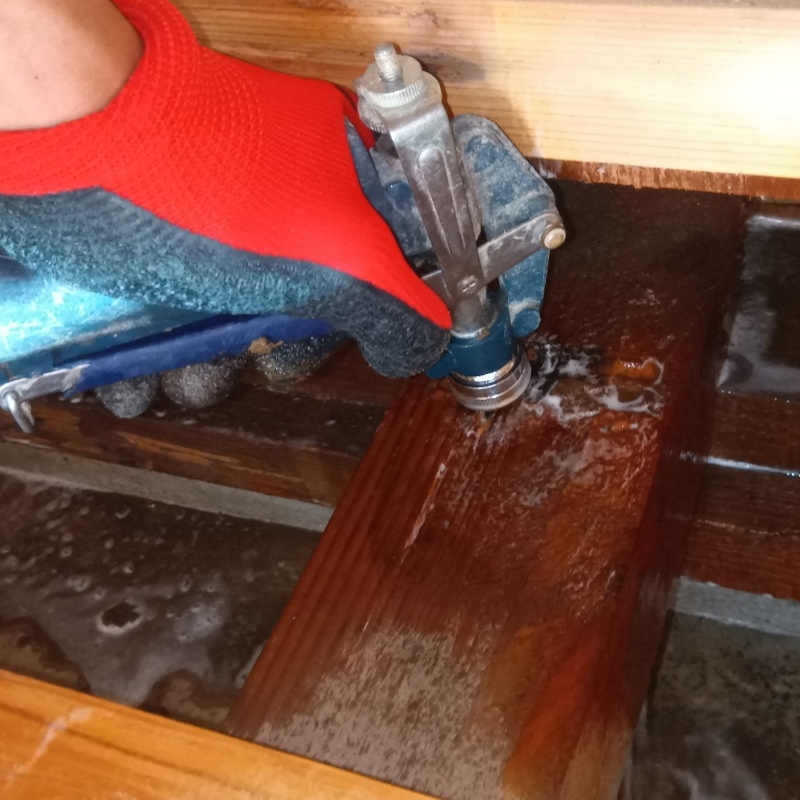 床下の木材にシロアリ駆除剤を注入する様子