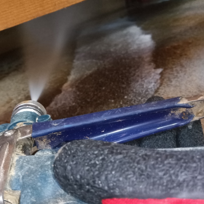 床下の土壌にシロアリ駆除剤を散布する様子