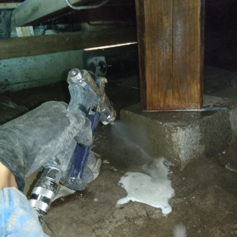 床下の基礎部分にシロアリ駆除剤を散布する様子