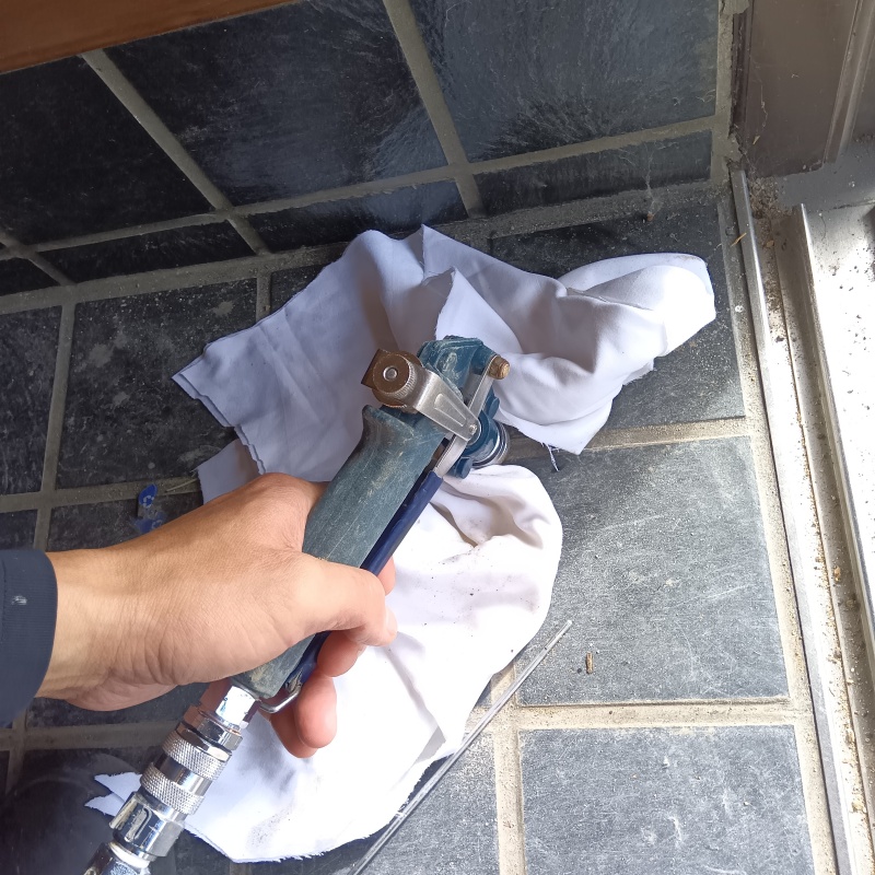 玄関の床にシロアリ駆除剤を注入する様子