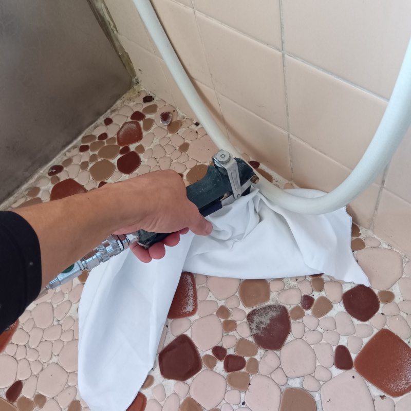 浴室の壁にシロアリ駆除剤を注入する様子