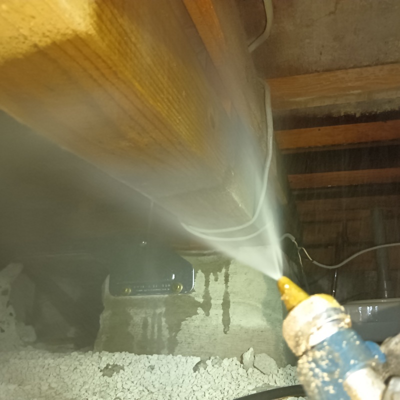 床下の木材に防蟻剤を散布する様子