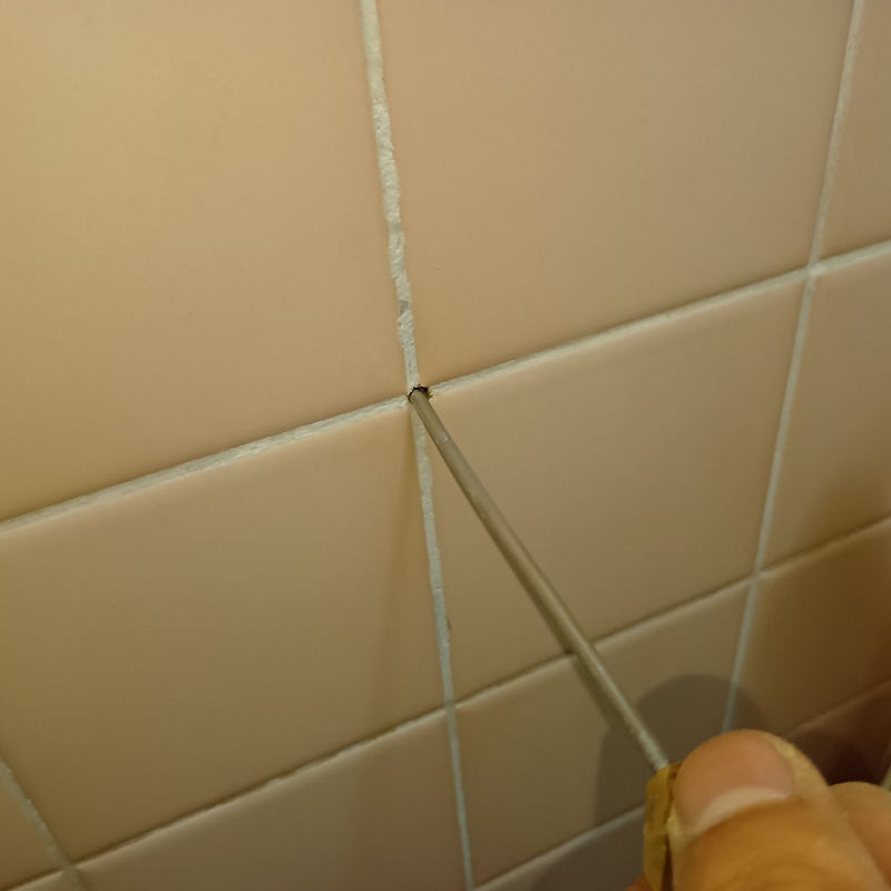 浴室の壁に防蟻剤を注入する様子