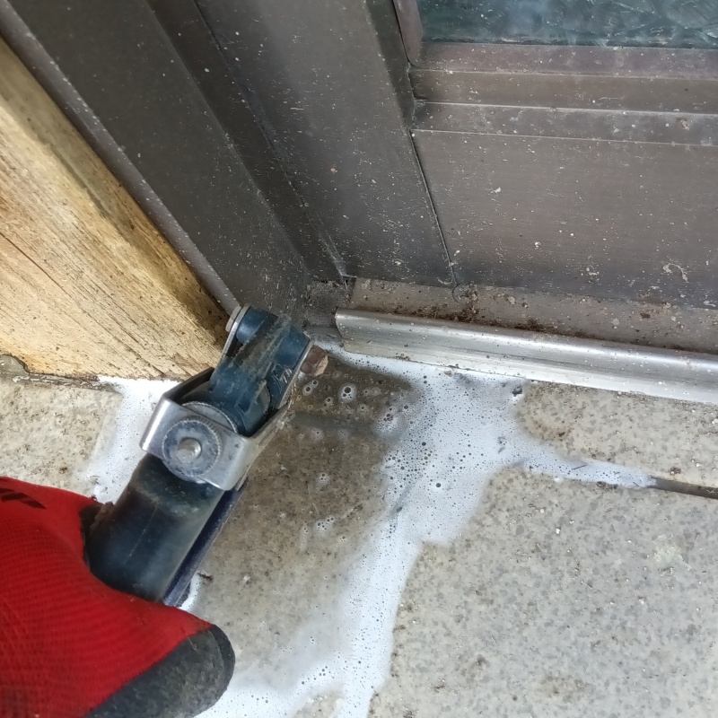 玄関の床にシロアリ駆除剤を注入する様子