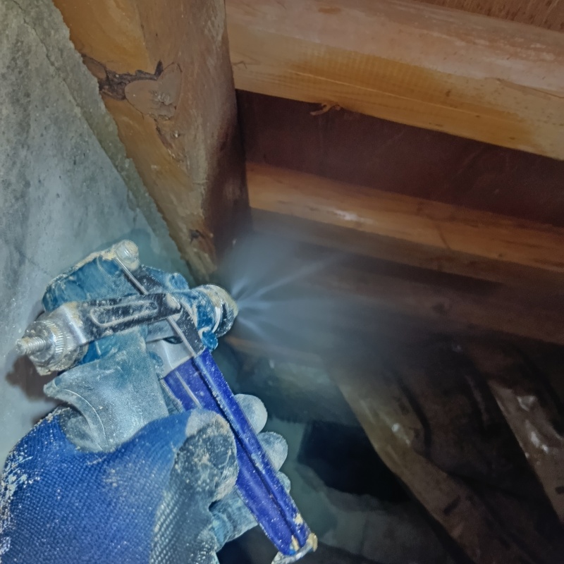 床下の木材にシロアリ駆除剤を散布する様子