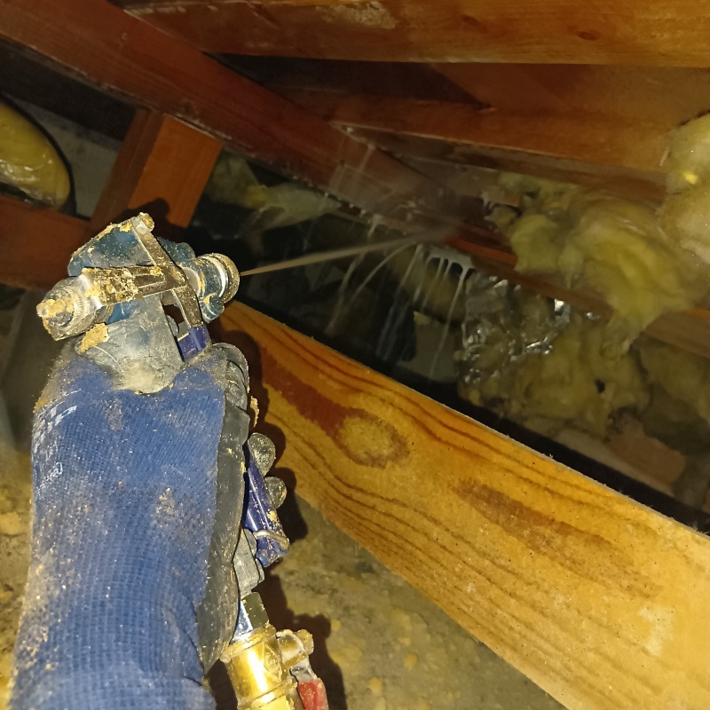 床下の基礎部分にシロアリ駆除剤を散布する様子