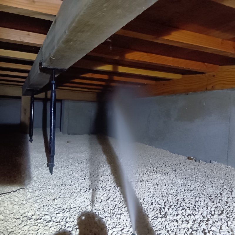 床下の基礎部分にシロアリ駆除剤を散布する様子