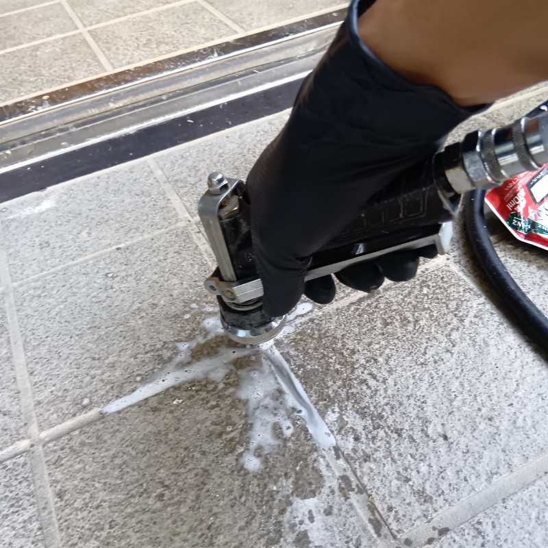 玄関の床にシロアリ駆除剤を注入する様子