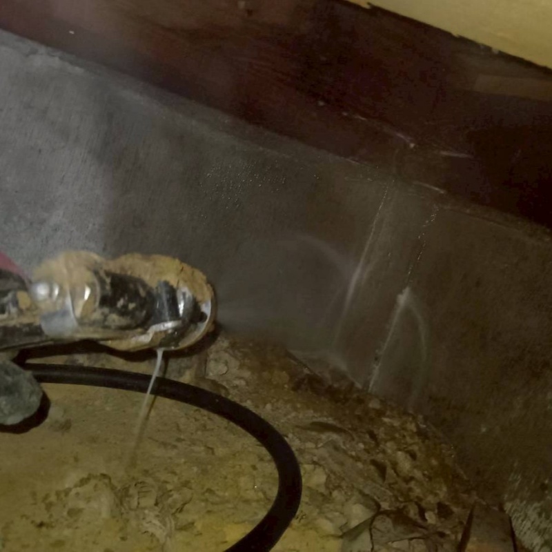 床下の基礎部分にシロアリ駆除剤を散布する様子