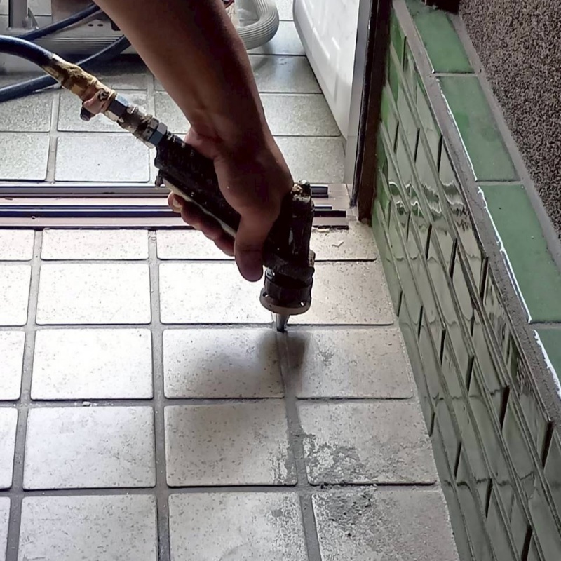 玄関の床にシロアリ駆除剤を注入する様子