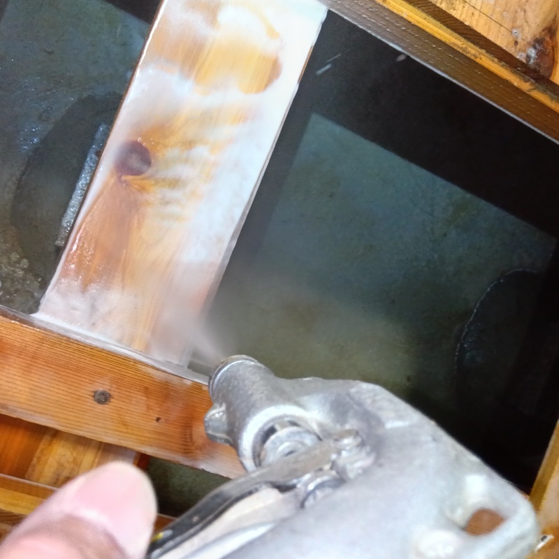 床下の木材にシロアリ駆除剤を散布する様子