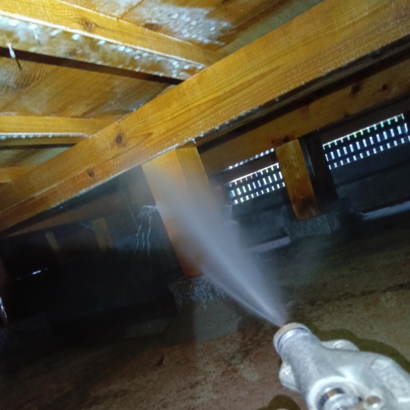 床下の木材にシロアリ駆除剤を散布する様子