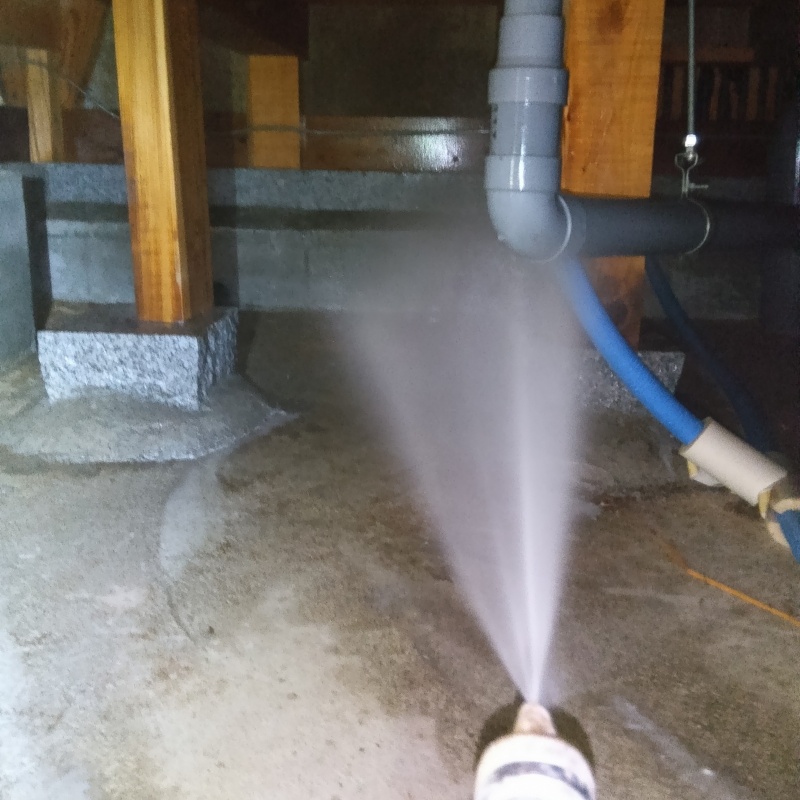 床下の基礎部分にシロアリ駆除剤を散布する様子