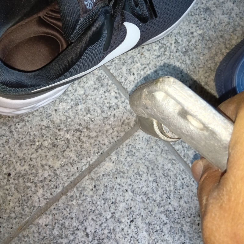 玄関の床にシロアリ駆除剤を注入する様子