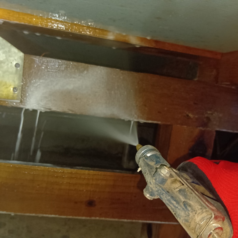 床下の木材にシロアリ駆除剤を散布する様子