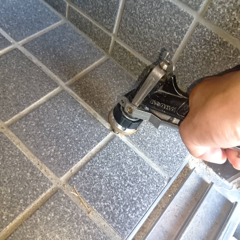 玄関の床にシロアリ駆除剤を注入する様子