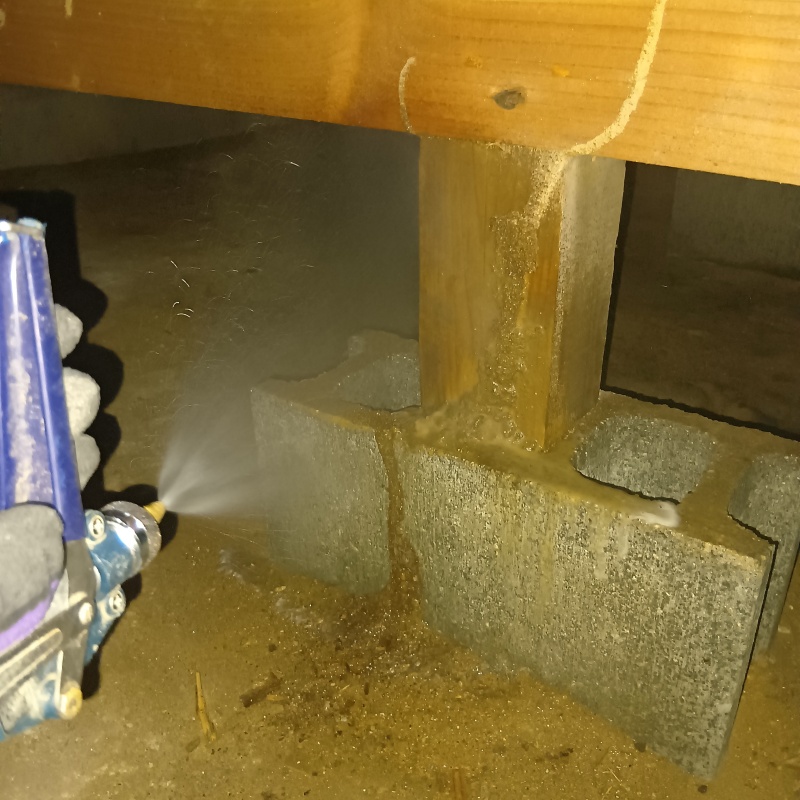 地面にシロアリ駆除剤を散布している様子