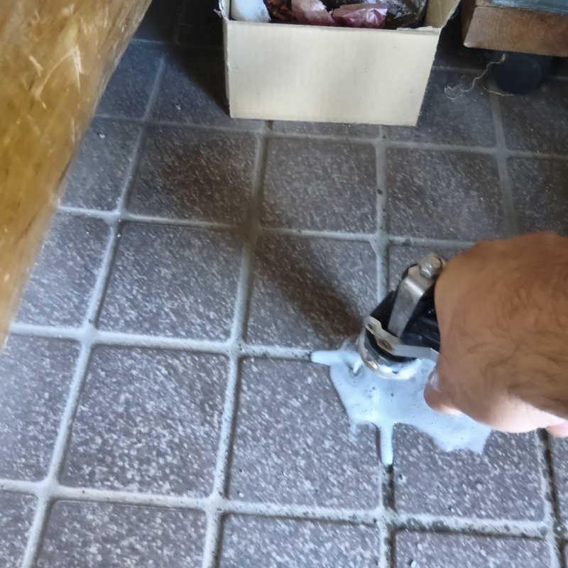 玄関床の目地に穴を開けてシロアリ駆除剤を注入
