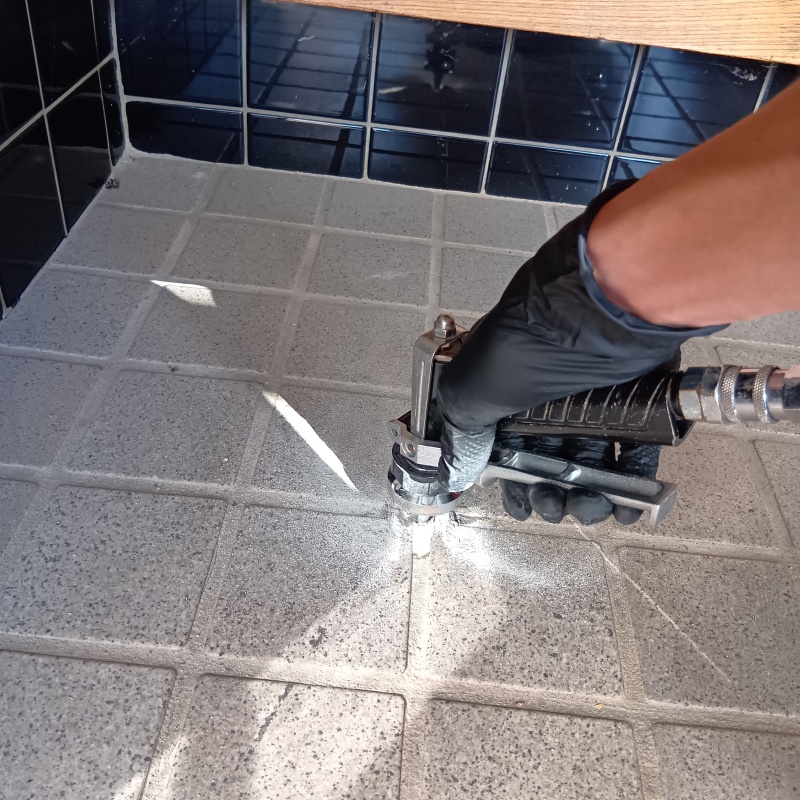 玄関床の目地に穴を開けてシロアリ駆除剤を注入