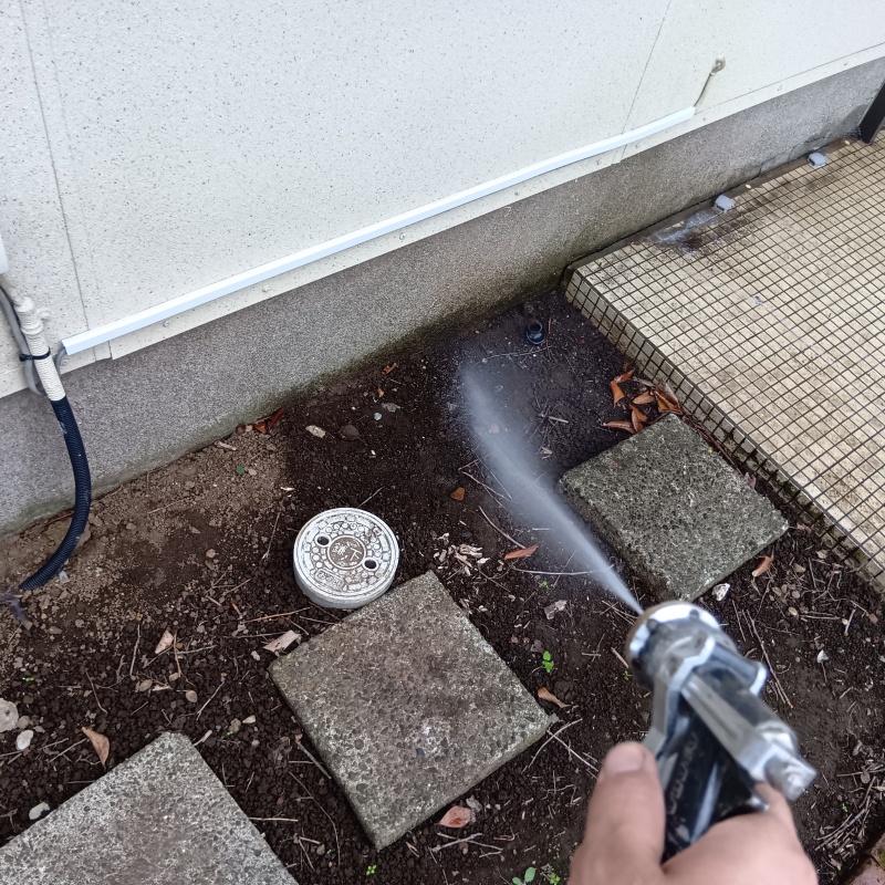 屋外の地面にシロアリ駆除剤を散布