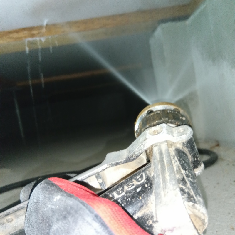 床下断熱材に防蟻剤を吹きつける様子