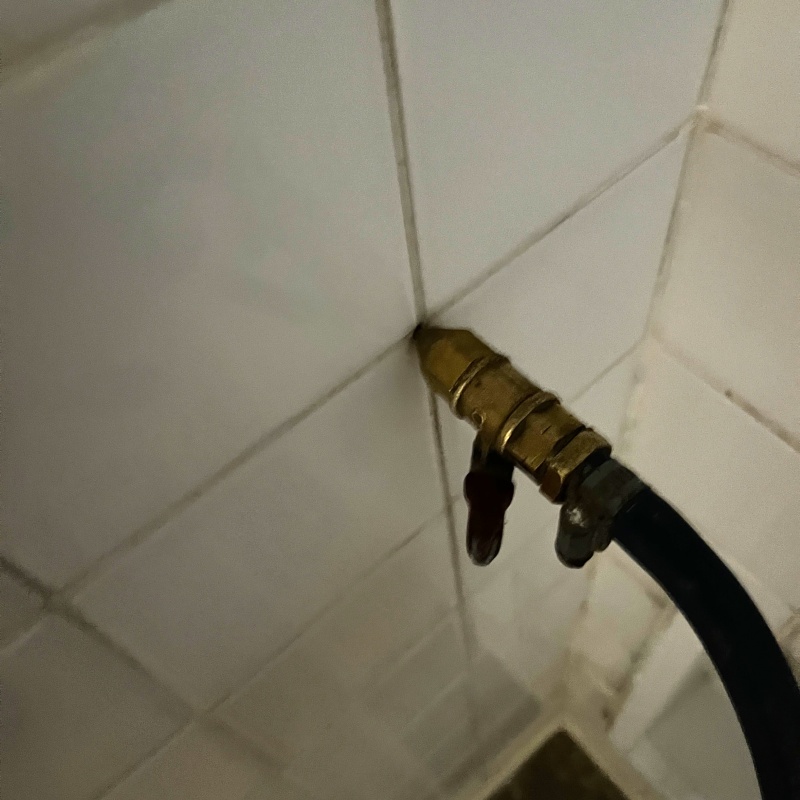 トイレの壁の目地からシロアリ駆除剤を注入