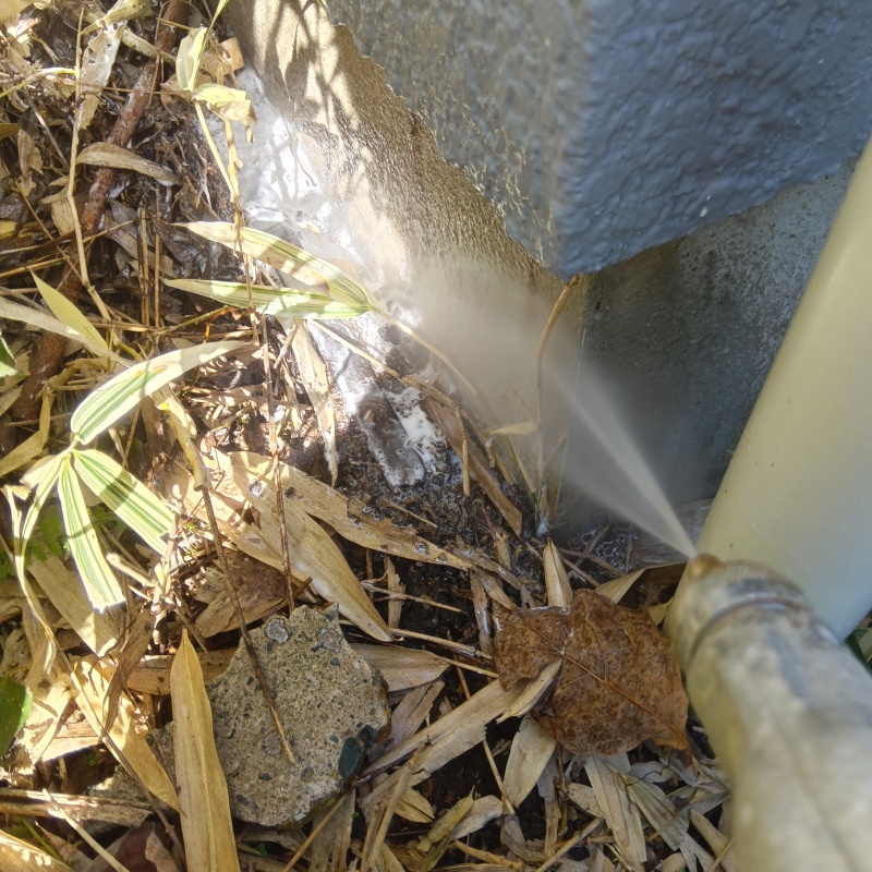 基礎まわりにシロアリ駆除剤を散布する様子