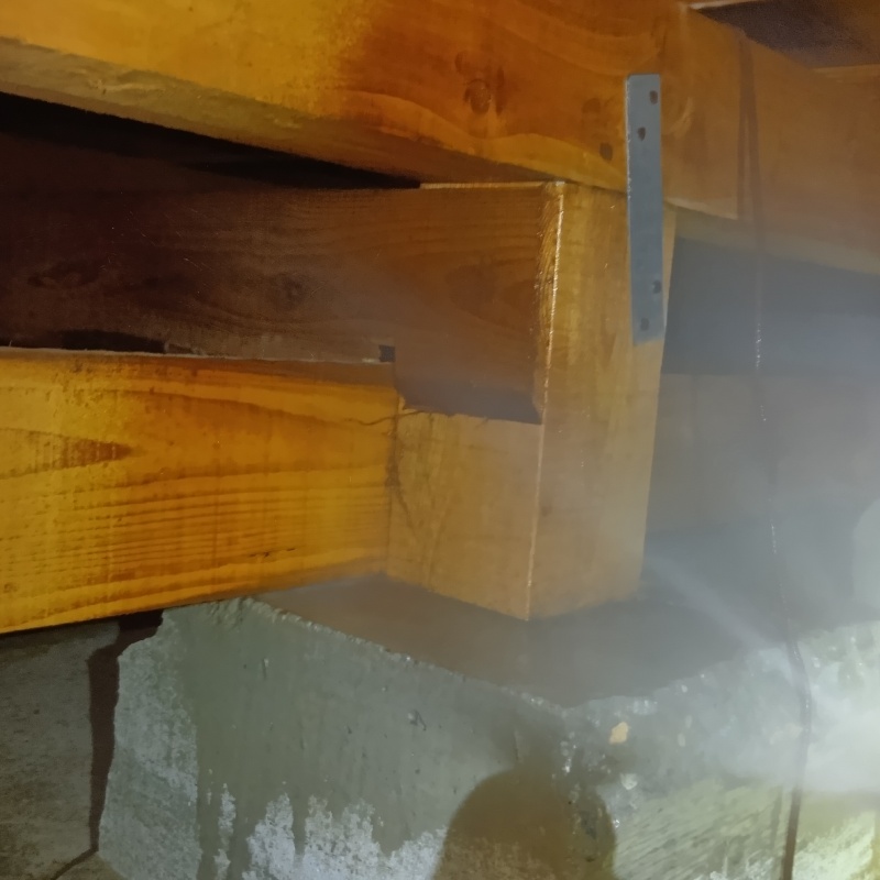 束石まわりにシロアリ駆除剤を吹きつけている様子