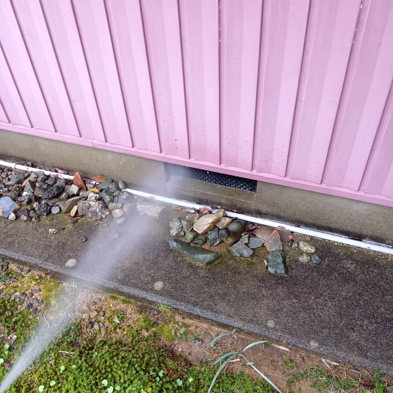 基礎まわりにシロアリ駆除剤を散布する様子