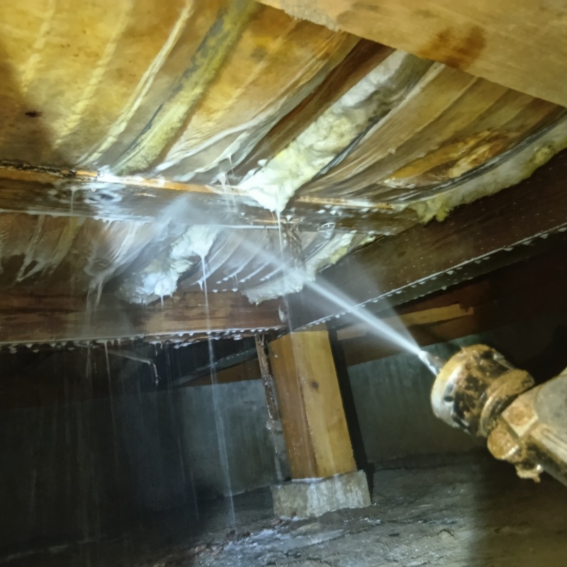 床下断熱材にシロアリ駆除剤を吹きつける様子