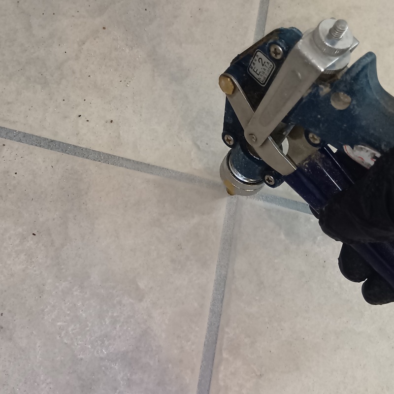 玄関床の目地から防蟻剤を注入している様子