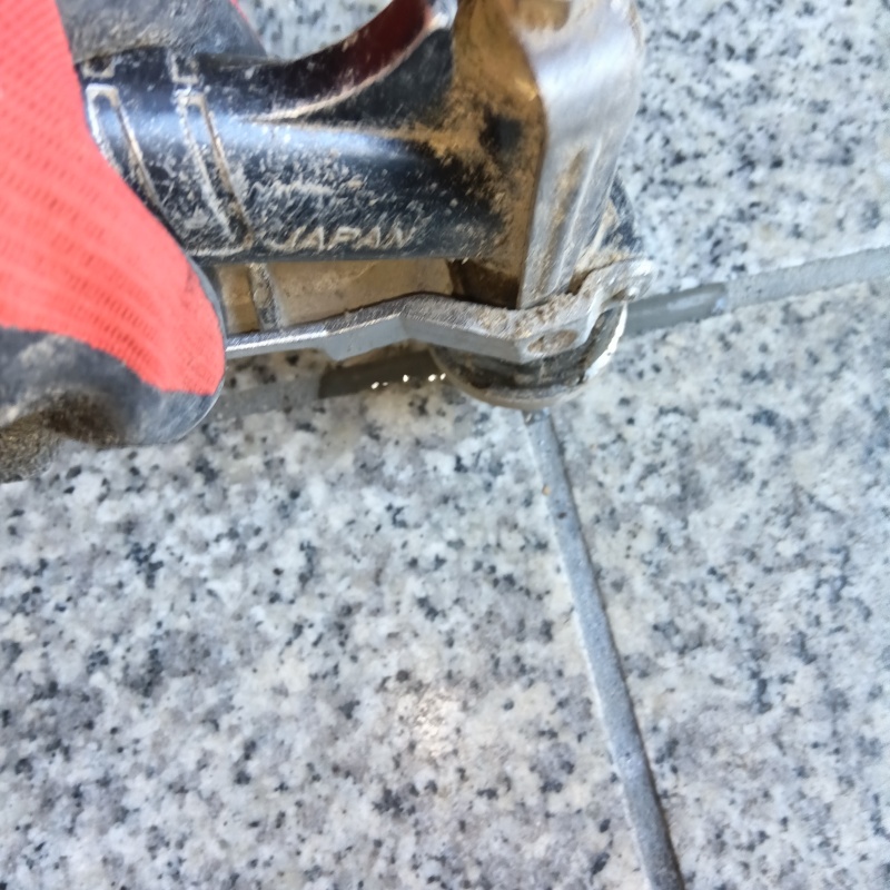 玄関床の目地からシロアリ駆除剤を注入している様子