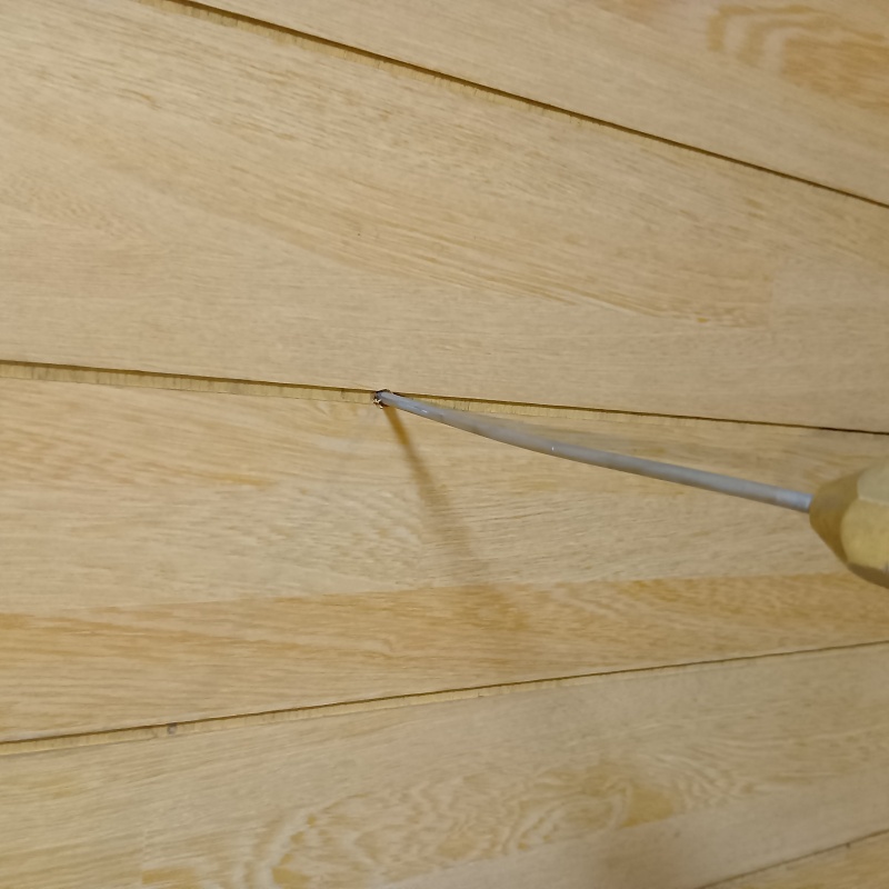 壁に穴を開けて内部にシロアリ駆除剤を注入している様子