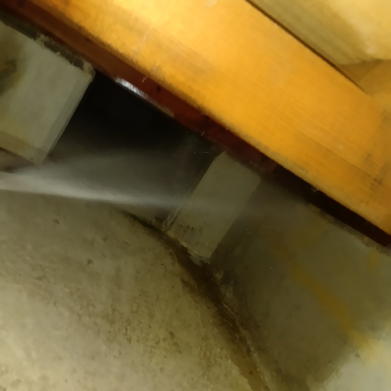 床下基礎のコンクリートにシロアリ駆除剤を吹きつけている様子