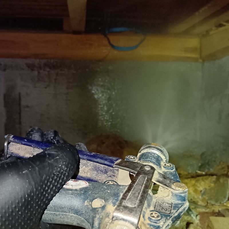 基礎部分にシロアリ駆除剤を吹きつけている様子