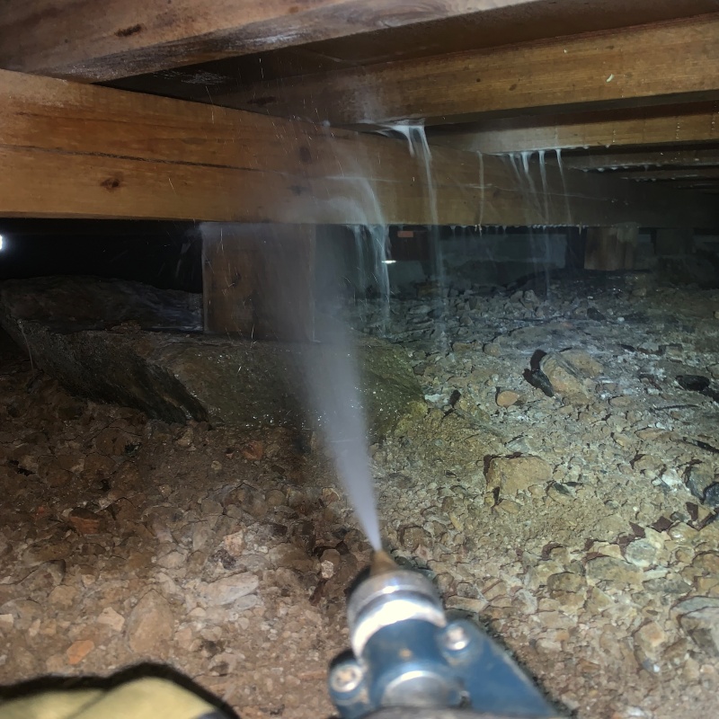 床下の木材にシロアリ駆除剤を散布している様子