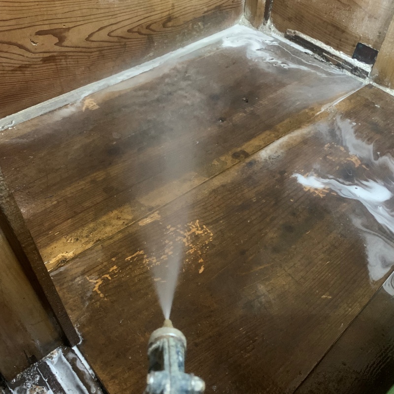 床材にシロアリ駆除剤を散布している様子