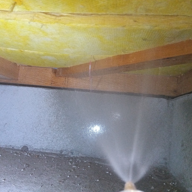 木材とコンクリートのすき間にシロアリ駆除剤を散布