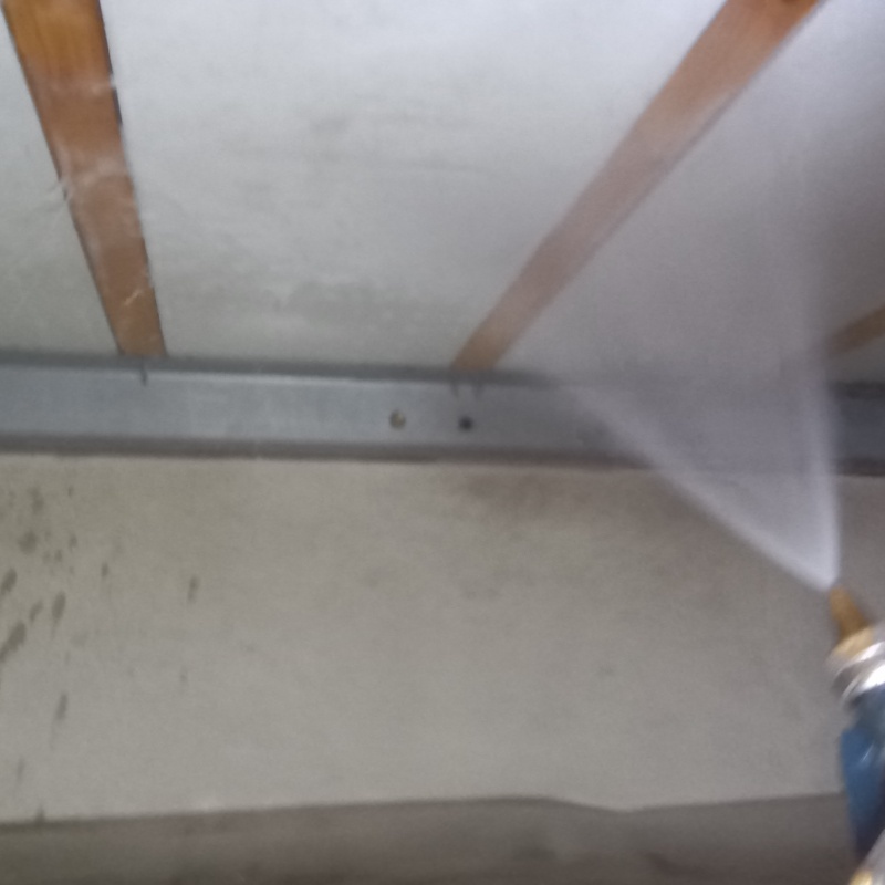 床下の木材にシロアリ駆除剤を吹きつけている様子