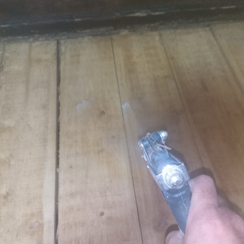 床に穴を開けてシロアリ駆除剤を注入している様子