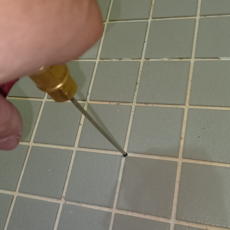 浴室の床に防蟻剤を注入している様子