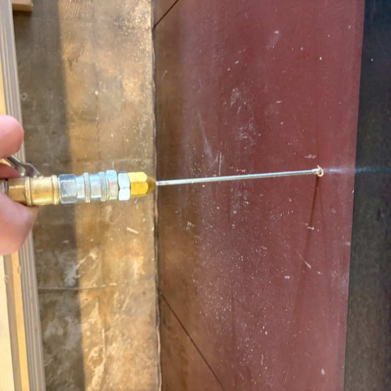 壁に開けた穴からシロアリ駆除剤を注入