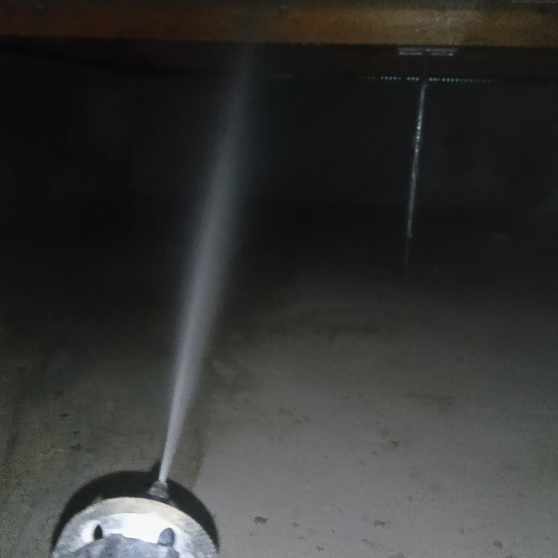 床下断熱材に防蟻剤を吹きつける様子