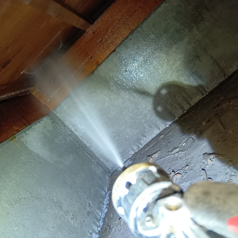 床下木材にシロアリ駆除剤を散布する様子