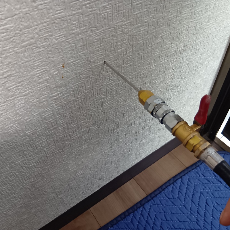 壁内にシロアリ駆除剤を注入している様子