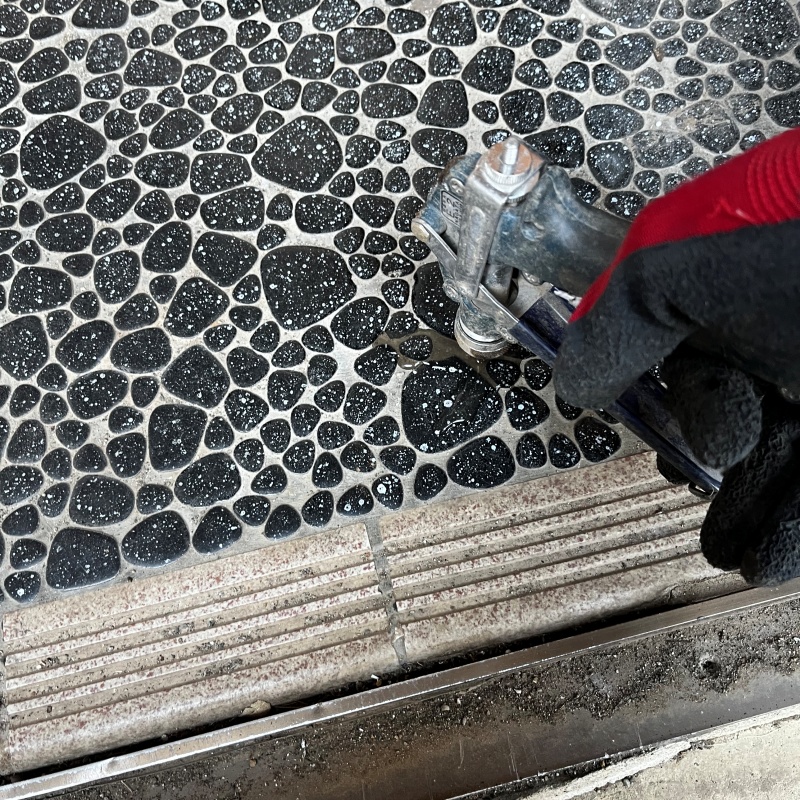 玄関床に穴を開けてシロアリ駆除剤を注入している様子