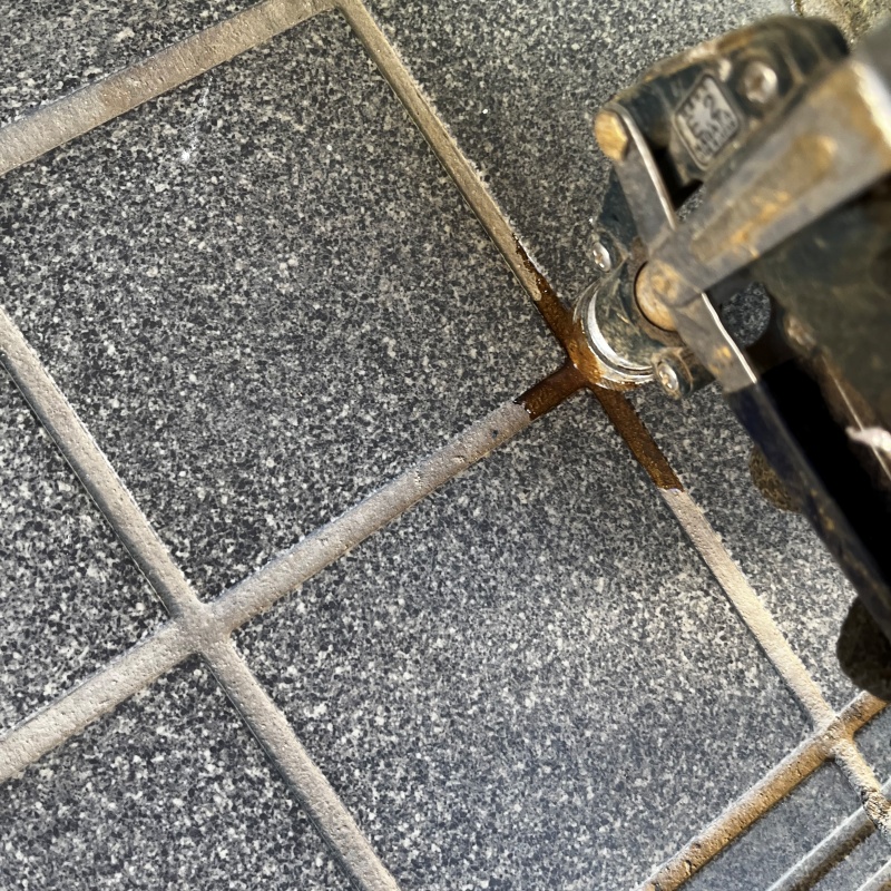 玄関床の目地に穴を開けてシロアリ駆除剤を注入