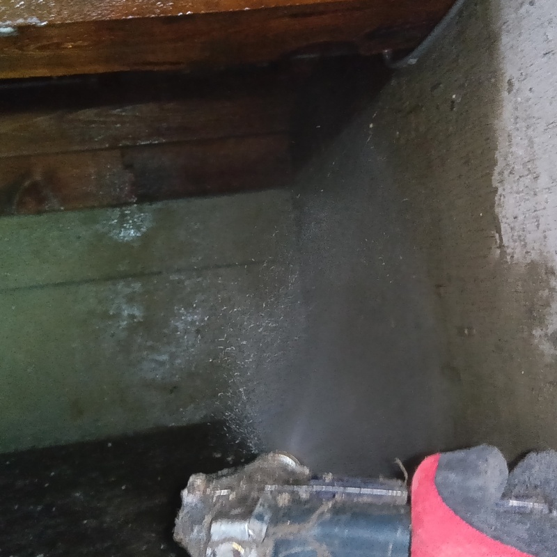 床下の基礎部分にシロアリ駆除剤を散布する様子