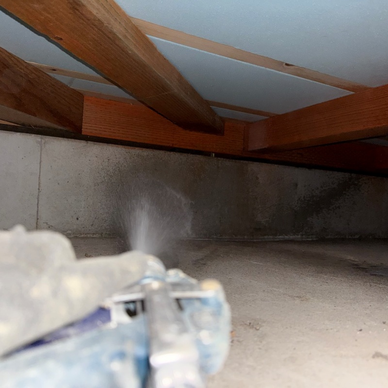 基礎の立ち上がり部分に防蟻剤を散布する様子